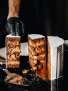 Amazing Cakes. A black-gloved chef is slicing a chocolate wedding cake. The wedding Cake is delicious inside on a black background Royalty Free Stock Photo