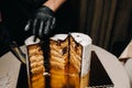 Amazing Cakes. A black-gloved chef is slicing a chocolate wedding cake. The wedding Cake is delicious inside on a black background Royalty Free Stock Photo