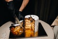 Amazing Cakes. A black-gloved chef is slicing a chocolate wedding cake. The wedding Cake is delicious inside on a black background Royalty Free Stock Photo
