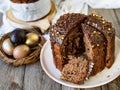 Amazing Chocolate Easter Cake with chocolate drops and dry cherries on an old wooden background with black and golden eggs. Slice