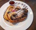 amazing chocolate french toast at brunch restaurant with chocolate garnish and syrup on the side behind it