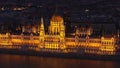 Amazing cinematic shot of Orszaghaz at night. Breathtaking illuminated building of Hungarian parliament on Danube river