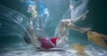 Amazing cinematic under water shot, young woman slowly sinks surrounded by single use plastic garbage waste slow motion.