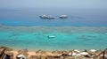An amazing clear Red sea with coral reefs. Boats, umbrellas, sun beds. Farsha beach sharm el sheikh, Egypt