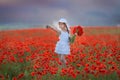 Amazing close up portrait of lovely cute young romantic girl with poppy flower in hand posing on field background. Wearing straw Royalty Free Stock Photo