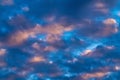 Amazing clouds in blue sky, illuminated by rays of sun at sunset to change weather. Colorful abstract cloudscape Royalty Free Stock Photo