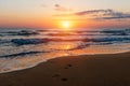 Amazing colorful sunrise at sea, footprints in the sand Royalty Free Stock Photo