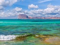 Amazing crystal clear blue water on a paradise beach - small wave - rocky island in the background Royalty Free Stock Photo