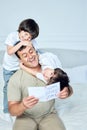 Amazing dad. Little latin boys, brothers embracing dad and giving him handmade postcard, congratulating with Father& x27;s Royalty Free Stock Photo