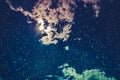 Amazing dark night sky with many stars, bright full moon and cloudy. Cross process. Royalty Free Stock Photo