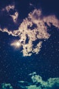 Amazing dark night sky with many stars, bright full moon and cloudy. Cross process. Royalty Free Stock Photo