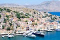 Amazing detailed view on small colorful houses on rocks and sailing boats on dock near the Mediterranian sea on Greek island in su