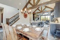 Amazing dining room near modern and rustic luxury kitchen with vaulted ceiling and wooden beams, long island with white quarts Royalty Free Stock Photo