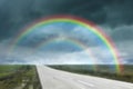 Amazing double rainbow over road under stormy sky, blurred view Royalty Free Stock Photo
