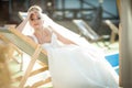 Amazing elegance cute stilysh blonde bride is posing on the bac