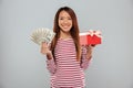 Amazing emotional young asian lady holding gift and money. Royalty Free Stock Photo