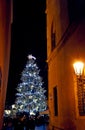 amazing fairytale Christmas tree in the old town and an old lantern on the wall on a narrow street in Prague Royalty Free Stock Photo