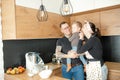 Amazing family of little boy, young woman, man standing in kitchen at home. Smiling father holding baby son on hands. Royalty Free Stock Photo