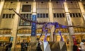 amazing fragment of view of giant dinosaur skeleton against lighted interior wall with people in background