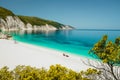 Amazing Fteri beach lagoon, Cephalonia Kefalonia, Greece. Tourists under umbrella relax near clear blue emerald turquise