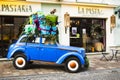 Amazing, funny blue retro car with a Christmas tree and gift boxes on the roof in the cute city of Chernivtsi, Ukraine