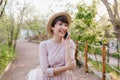 Amazing girl with short dark hair speaking on phone and looking up with smile. Outdoor portrait of inspired young lady Royalty Free Stock Photo