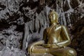 Amazing gold buddha statue in beautiful cave, holy natural buddhist sanctuary in Thailand Royalty Free Stock Photo