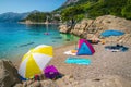 Amazing gravelly beach with colorful parasols and towels