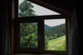 Amazing green view through window of wooden rustic house