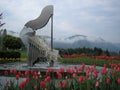 The amazing Harp Fountain with water strings surrounded by beautiful tulips in Ossiach