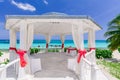 Amazing inviting view of decorated wedding gazebo at tropical beach on blue sky and tranquil ocean background