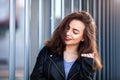 Amazing joyful pretty girl with long brunette hair. posing outdoor. leather jacket,brunette hair, bright red lips Close up fashion Royalty Free Stock Photo