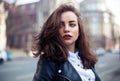 Amazing joyful pretty girl with long brunette hair. posing outdoor. leather jacket,brunette hair, bright red lips Close up fashion Royalty Free Stock Photo