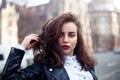 Amazing joyful pretty girl with long brunette hair. posing outdoor. leather jacket,brunette hair, bright red lips Royalty Free Stock Photo