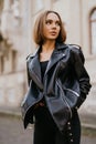 Amazing joyful pretty girl posing outdoor. leather jacket,brunette hair, bright red lips Close up fashion street stile portrait Royalty Free Stock Photo