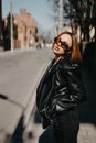 Amazing joyful pretty girl posing outdoor. leather jacket,brunette hair, bright red lips Close up fashion street stile portrait Royalty Free Stock Photo