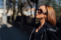 Amazing joyful pretty girl posing outdoor. leather jacket,brunette hair, bright red lips Close up fashion street stile portrait Royalty Free Stock Photo