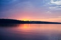Amazing lake landscape in the evening. Purple orange blue red cloudy sky and setting sun with reflection in water at sunset.Nature Royalty Free Stock Photo