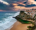 Amazing landscape of the Atlantic ocean shore in Azenhas do Mar village at sunset. View of of the sandy cove and dramatic cliffs. Royalty Free Stock Photo