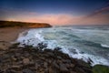 Amazing landscape on the Atlantic ocean at sunrise. View of dramatic cloudy sky, sandy beach and stony coast. Beach of Praia das M Royalty Free Stock Photo