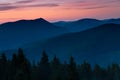 Amazing landscape in the layers of mountains at the dusk. View of colorful sky and hills covered by forest. Royalty Free Stock Photo