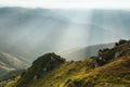 Amazing landscape in the mountains at morning. View of sun rays over hills and valleys. Beam of light from clouds on the mountains Royalty Free Stock Photo