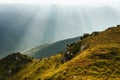 Amazing landscape in the mountains at morning. View of sun rays over hills and valleys. Beam of light from clouds on the mountains Royalty Free Stock Photo