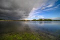 Amazing landscape of nature before thunder storm. Dark clouds cover blue sky at wild river. Incredible weather Royalty Free Stock Photo