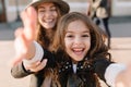 Amazing laughing young woman holding her daughter`s hands, while she having fun in front of camera. Portrait of charming Royalty Free Stock Photo