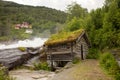 Amazing little wooden small house next to a waterfall on the dock of Hellesylt, child playing in the house