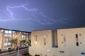 Amazing long exposure shot of a white thunder into a electric storm with grey clouds and night neighborhood bogota city Royalty Free Stock Photo