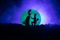 Amazing love scene. Silhouettes of man making proposal to woman or Silhouettes of couple against big moon at background