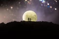 Amazing love scene. Silhouettes of young romantic couple standing under the moon light