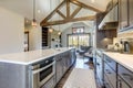 Amazing modern and rustic luxury kitchen with vaulted ceiling and wooden beams, long island with white quarts countertop